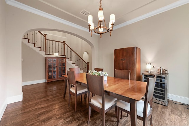 dining room featuring arched walkways, beverage cooler, wood finished floors, stairs, and an inviting chandelier