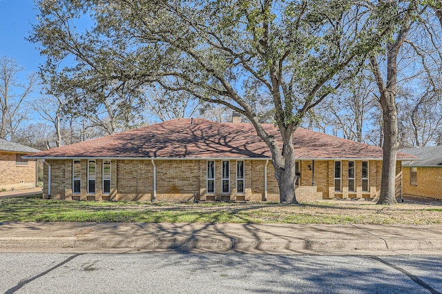 ranch-style house with brick siding and a front lawn