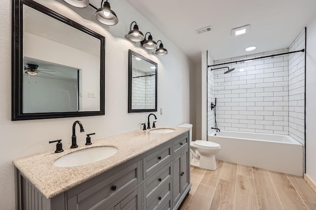 bathroom featuring wood tiled floor, visible vents, a sink, and toilet