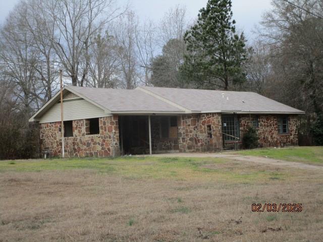 single story home with stone siding and a front lawn