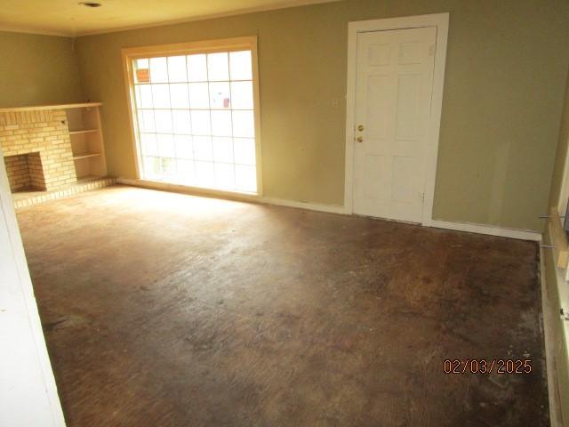 unfurnished living room featuring a fireplace and baseboards