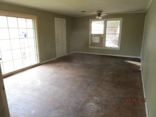 spare room with crown molding, baseboards, and ceiling fan