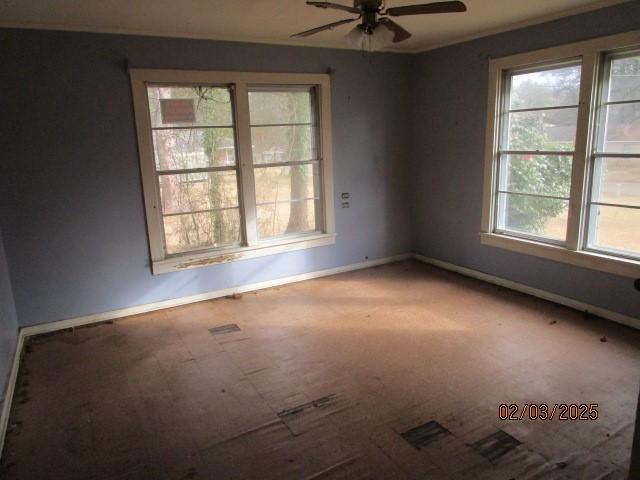 spare room featuring baseboards and a ceiling fan