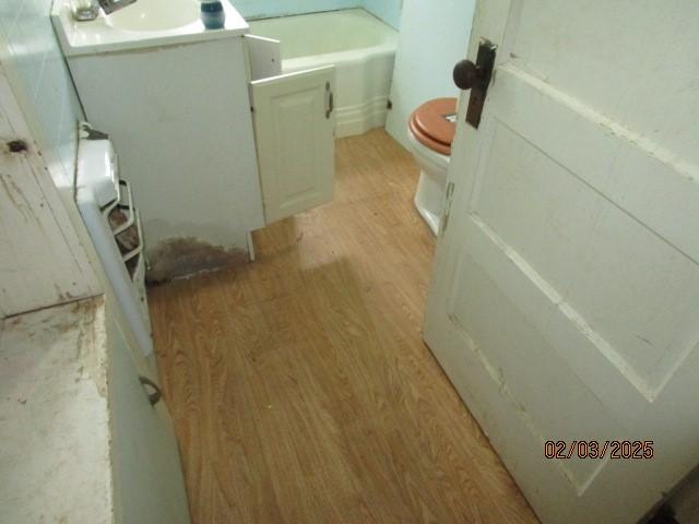 bathroom with toilet, wood finished floors, and vanity