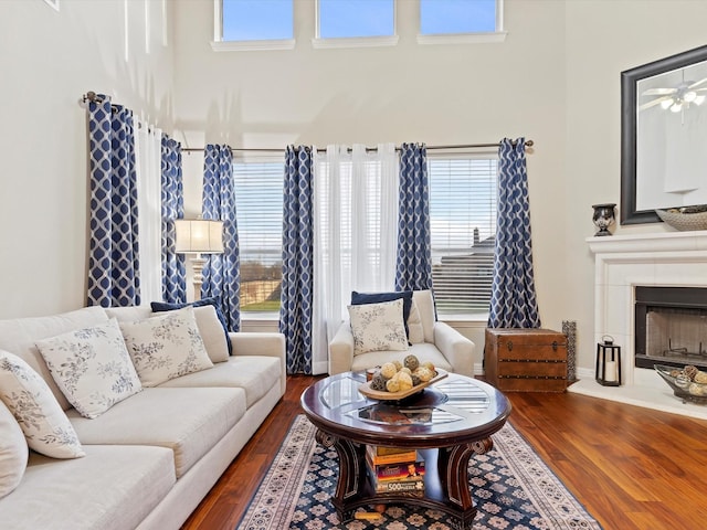 living area featuring a tile fireplace and wood finished floors