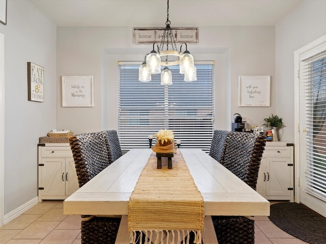 dining room featuring a notable chandelier, baseboards, and light tile patterned floors