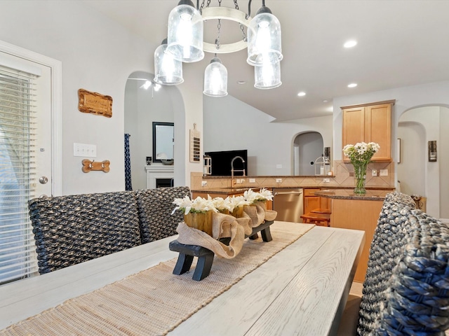 dining space with arched walkways, a fireplace, and recessed lighting