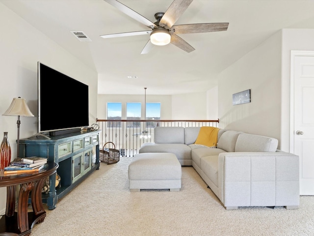 carpeted living room with ceiling fan and visible vents