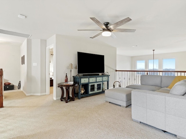 carpeted living area with baseboards, visible vents, and a ceiling fan