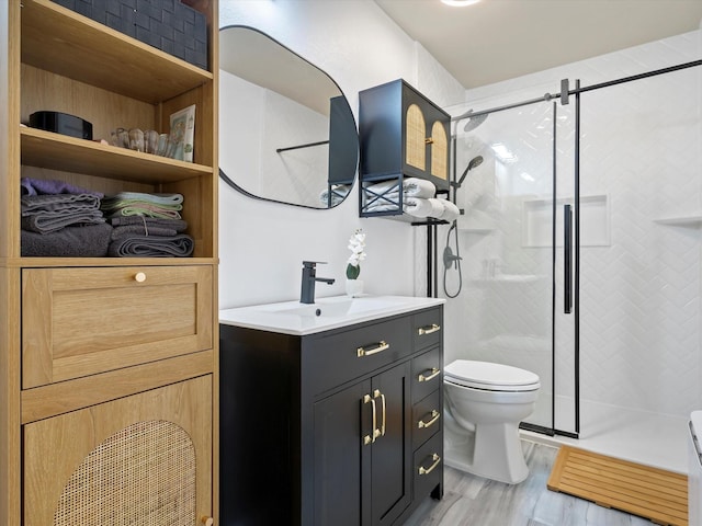 full bath with a stall shower, vanity, toilet, and wood finished floors