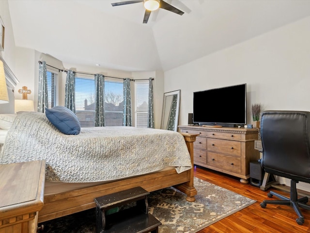 bedroom with ceiling fan, vaulted ceiling, and wood finished floors