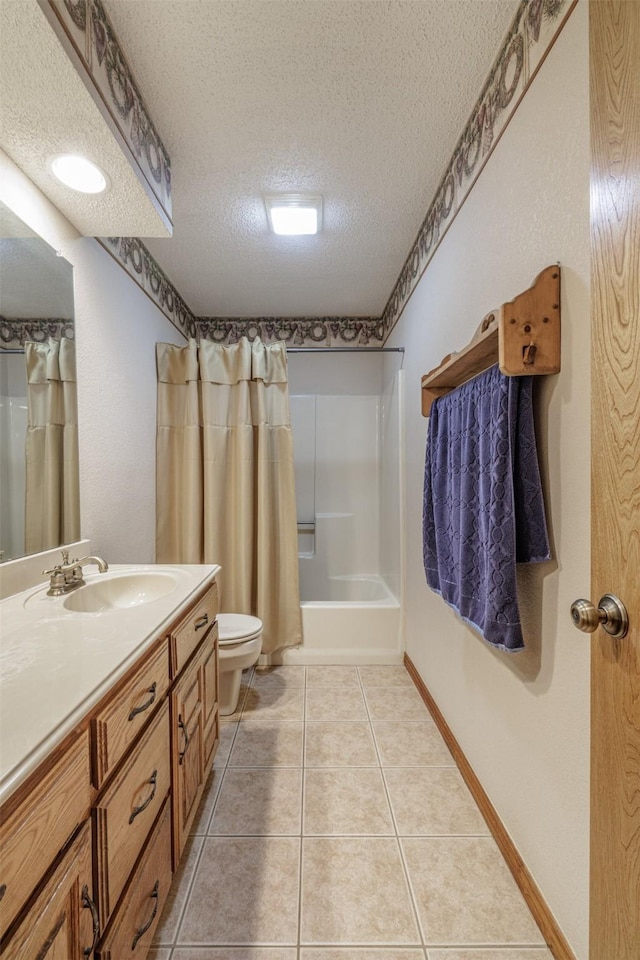 bathroom featuring a textured ceiling, toilet, vanity, baseboards, and tile patterned floors