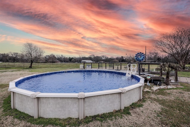 pool featuring a lawn and fence