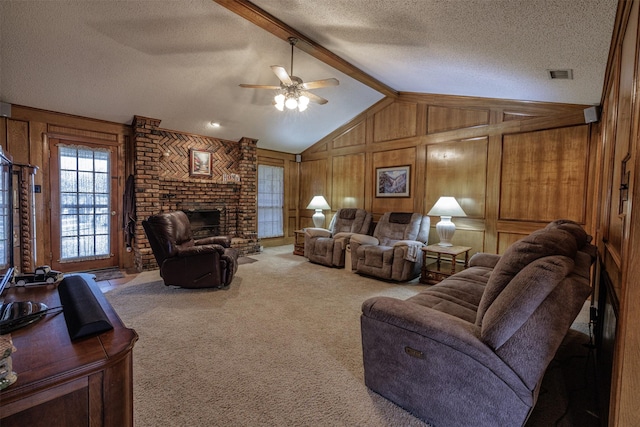 living area with a fireplace, visible vents, lofted ceiling with beams, carpet flooring, and a textured ceiling