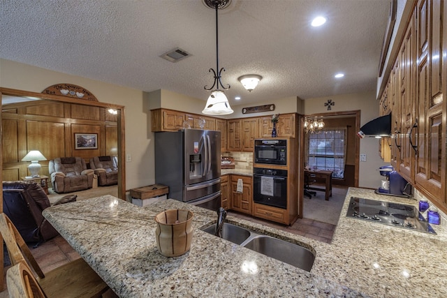 kitchen featuring electric stovetop, ventilation hood, stainless steel fridge, oven, and a peninsula