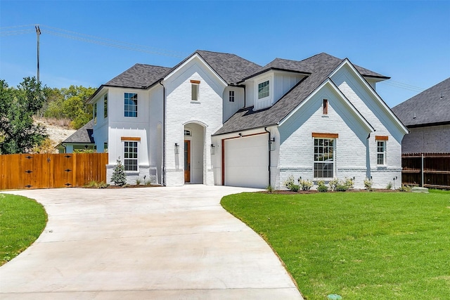 view of front of house featuring driveway, a gate, fence, a front lawn, and brick siding