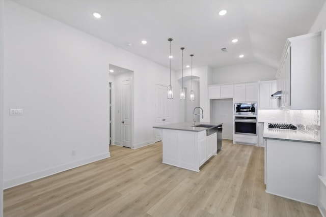 kitchen with a sink, white cabinetry, appliances with stainless steel finishes, light wood-style flooring, and exhaust hood