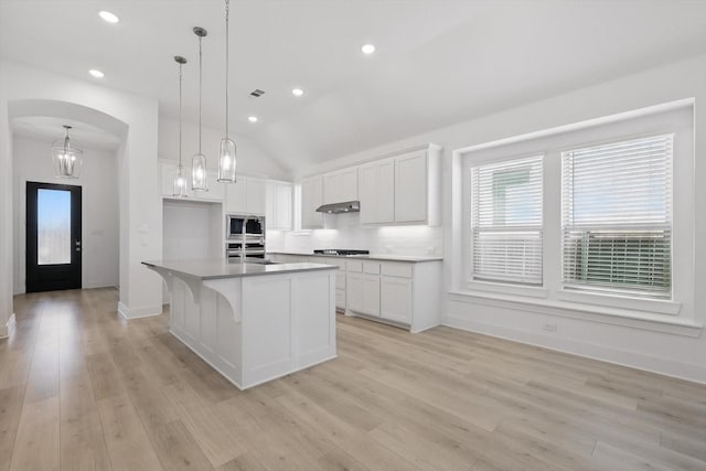 kitchen featuring white cabinetry, light wood-style floors, stainless steel appliances, and under cabinet range hood