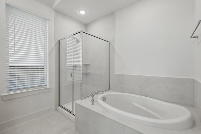 bathroom featuring a bath, baseboards, and a shower stall