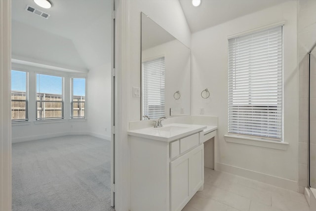 bathroom with baseboards, visible vents, vanity, and vaulted ceiling