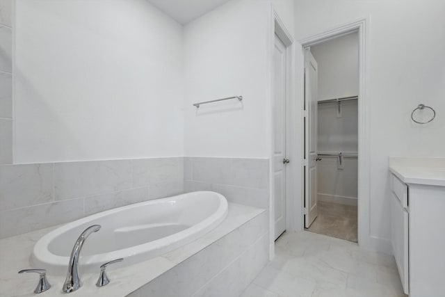 full bath with a bath, marble finish floor, a spacious closet, and vanity