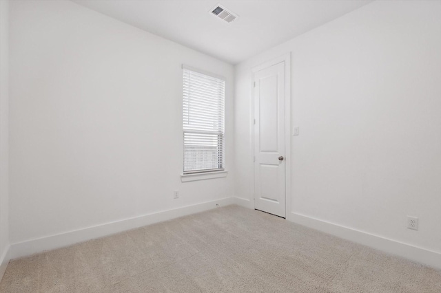 unfurnished room with light colored carpet, visible vents, and baseboards