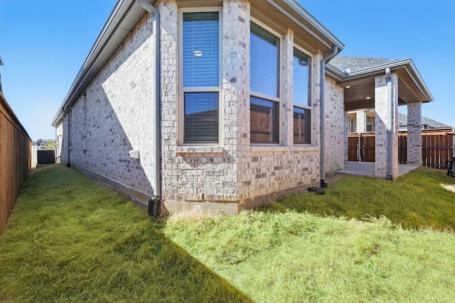 view of property exterior featuring a fenced backyard, a patio area, central AC, and a yard