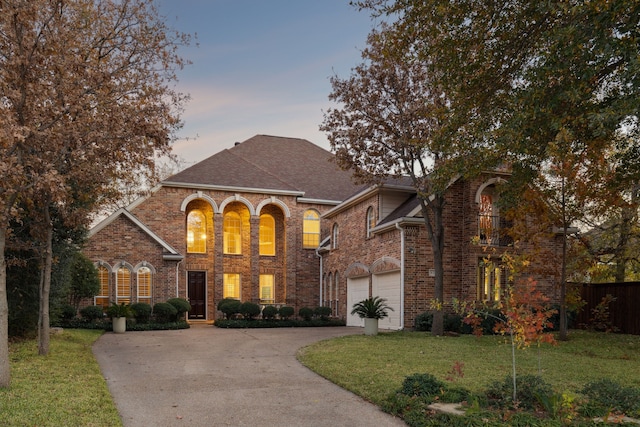 view of front of home featuring driveway, fence, a front lawn, and brick siding