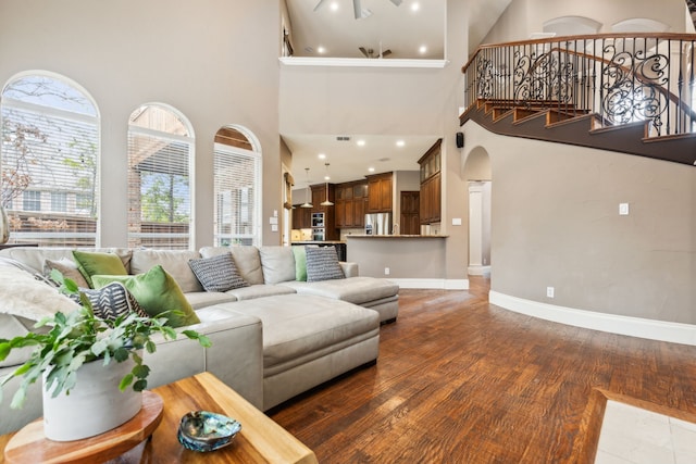 living room featuring stairway, plenty of natural light, baseboards, and wood finished floors