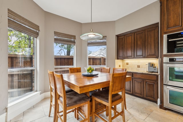 dining area featuring baseboards and stone tile floors