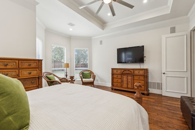 bedroom featuring visible vents, a tray ceiling, wood finished floors, and ornamental molding