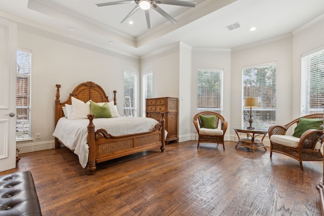 bedroom featuring baseboards, visible vents, a raised ceiling, ornamental molding, and hardwood / wood-style floors