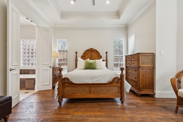 bedroom with wood finished floors, a raised ceiling, and crown molding