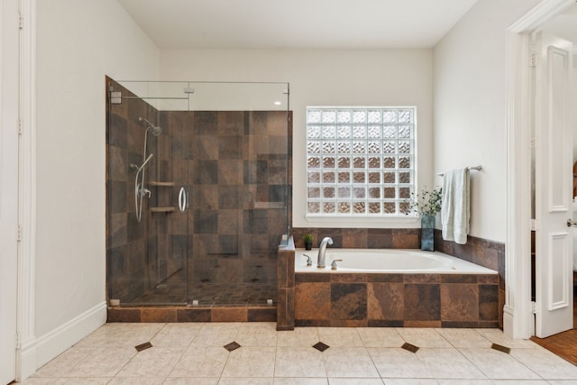 bathroom featuring a garden tub, a shower stall, and tile patterned flooring