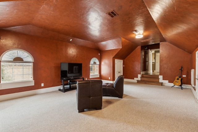 home theater with lofted ceiling, light carpet, visible vents, and baseboards