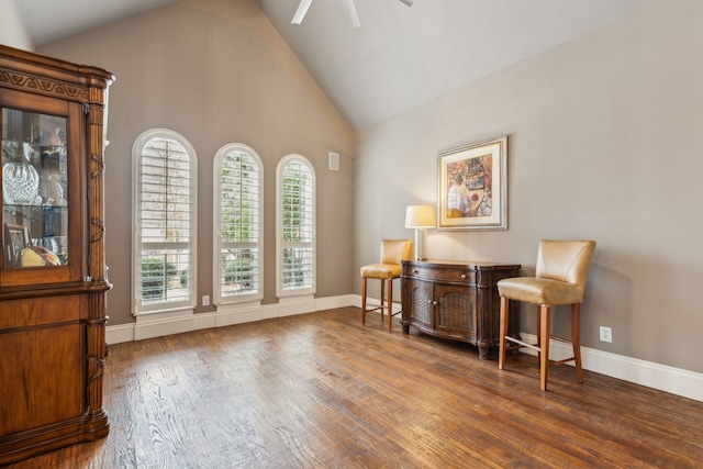 living area featuring high vaulted ceiling, wood finished floors, a ceiling fan, and baseboards