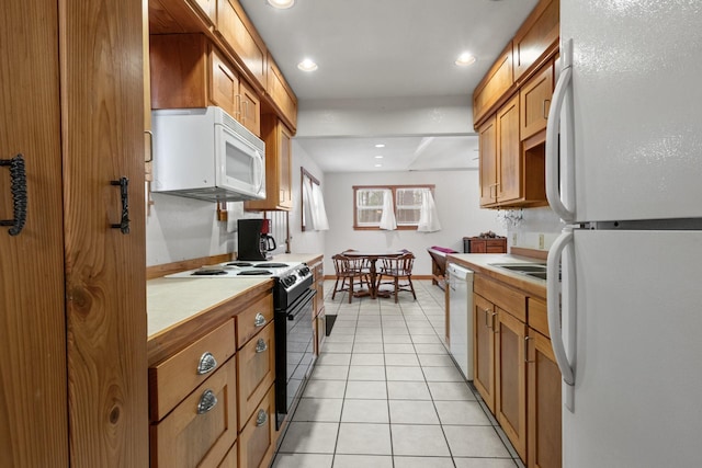 kitchen with white appliances, light tile patterned floors, baseboards, tile countertops, and brown cabinets