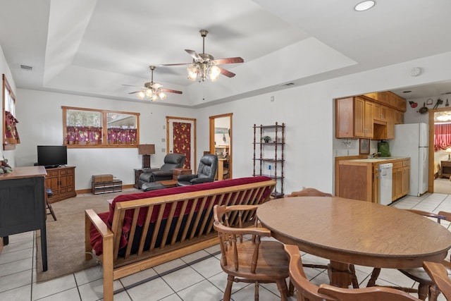 dining area featuring a raised ceiling, visible vents, and light tile patterned floors