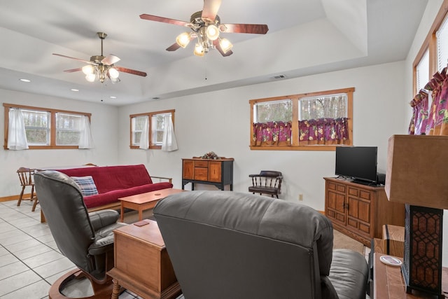 living room with light tile patterned flooring, recessed lighting, visible vents, baseboards, and a raised ceiling