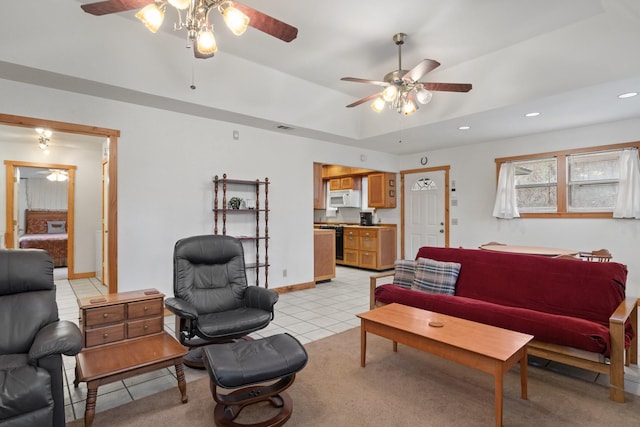 living room featuring light tile patterned floors, baseboards, a ceiling fan, a tray ceiling, and recessed lighting