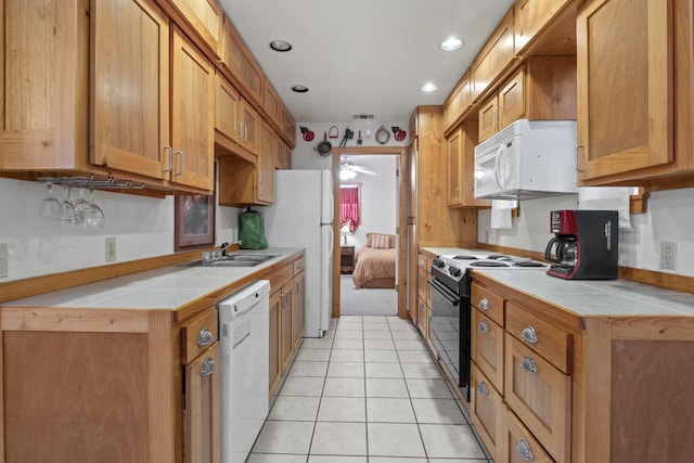 kitchen with light tile patterned floors, visible vents, ceiling fan, a sink, and white appliances