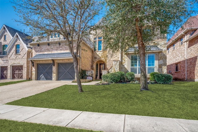 view of front of house featuring a garage, a front yard, stone siding, and driveway