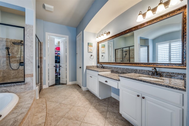 full bathroom with vanity, a shower stall, a walk in closet, and tile patterned floors