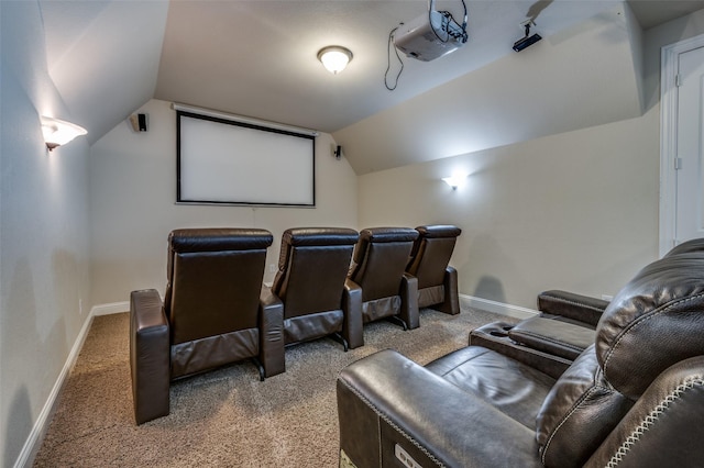 carpeted cinema room featuring vaulted ceiling and baseboards