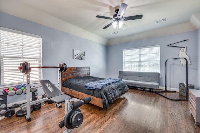 bedroom featuring visible vents, ceiling fan, baseboards, and wood finished floors