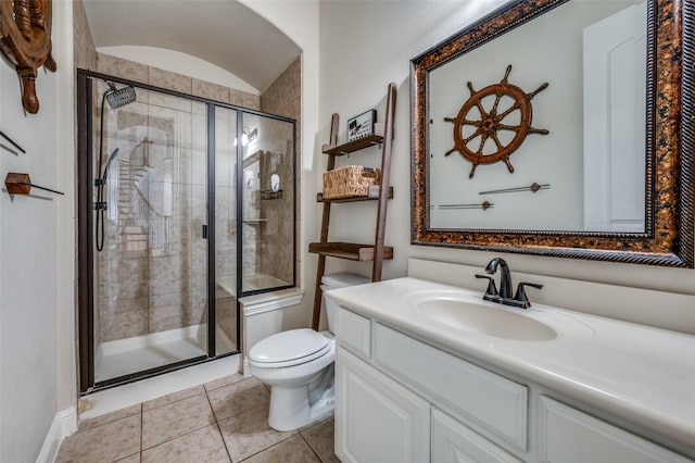 bathroom featuring vanity, a stall shower, tile patterned flooring, and toilet