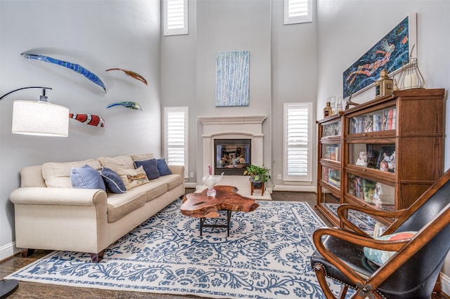 living area featuring plenty of natural light, a high ceiling, and a fireplace