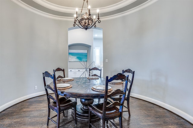 dining area featuring arched walkways, a tray ceiling, crown molding, a notable chandelier, and baseboards