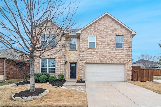 traditional home with a garage, driveway, brick siding, and fence