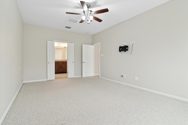 unfurnished bedroom with light colored carpet, visible vents, ceiling fan, ensuite bath, and baseboards